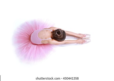 Little Ballerina Girl In A Pink Tutu Sit On Floor. Cute Preschool Child Dancing Classical Ballet In White Studio. Young Graceful Dancer Stretching In A Class.