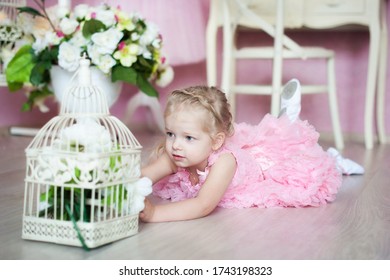 A Little Ballerina In A Pink Dress Lies On The Floor In A Dance Class