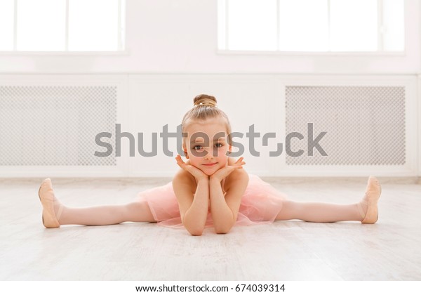 床に割った小さなバレリーナ コピー用スペース プロのバレエダンサーになりたいと願う笑顔のベビーガール クラシックダンススクール の写真素材 今すぐ編集