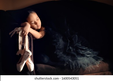 little ballerina is tired holding pointe shoes - Powered by Shutterstock