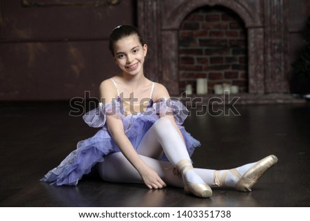 Little ballet dancer putting on pointes.