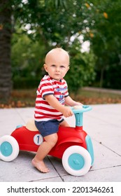 Little Barefoot Boy Sitting On A Toy Car