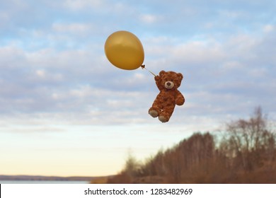 flying teddy bear with balloons