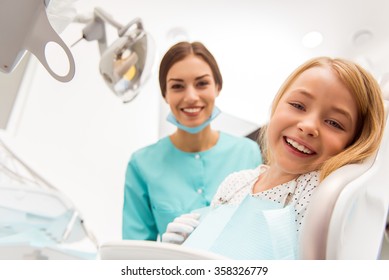 Little Beautiful Girl At The Dentist Looking At The Camera And Smiling