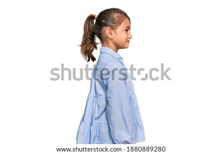 Little beautiful girl wearing casual clothes looking to side, relax profile pose with natural face with confident smile. 
