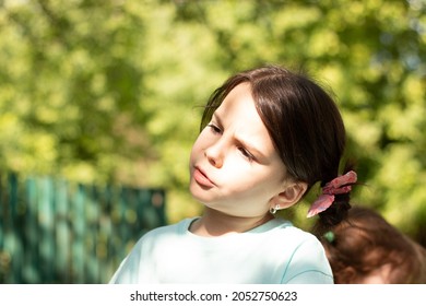 Little beautiful white girl with big eyes looks to the side with concentration on a blurred rustic background with bokeh - Powered by Shutterstock