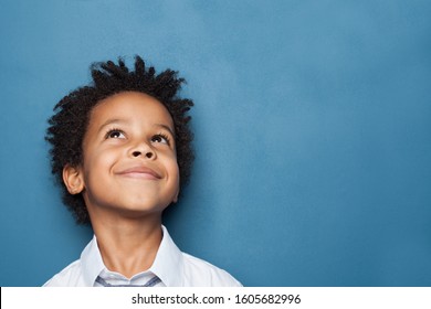 Little Black Child Boy Smiling And Looking Up On Blue Background