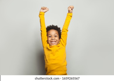 Little black child win-win! Kid boy having fun on white background