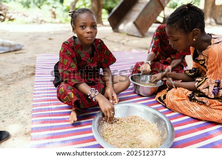 Little black ethnicity African girl with a full mouth chewing her food with relish