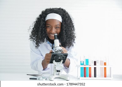 Little Black Girl Smile With A Microscope Various Colorful Flasks And Test Tube On A White Background