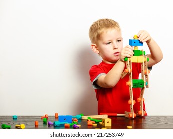 Little Blond Boy Child Kid Preschooler Playing With Colorful Building Blocks Toys Interior. At Home. Childhood And Development.