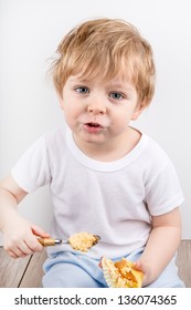 Little Blond Boy Of Two Years Eating Cheesecake Muffin.