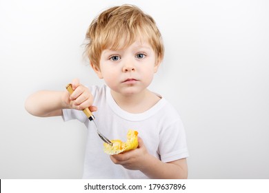 Little Blond Boy Of Two Years Eating Cheesecake Muffin.