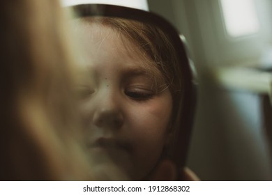 Little Blond Girl With Blue Eyes Looking In The Mirror. Cute Serious Curious Child Admires Herself In Reflection. Kids Home Portrait In Daylight Near Window. Growing Up Psychology Personal Development