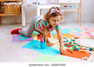 Little Blond Girl With Cat Ears Rim Prepare Colorful Cardboard Papers For Handmade Cut And Arts, Have Fun In Kid Development Center. Playroom Activity And Daycare. Nursery School And Early Education