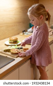 Little Blond Girl Is Cooking Home Made Burgers In Her Kitchen At Home