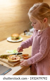 Little Blond Girl Is Cooking Home Made Burgers In Her Kitchen At Home