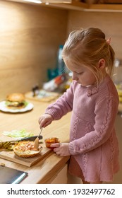 Little Blond Girl Is Cooking Home Made Burgers In Her Kitchen At Home