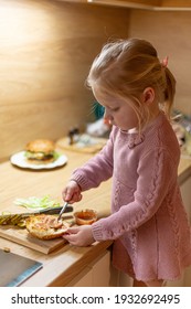 Little Blond Girl Is Cooking Home Made Burgers In Her Kitchen At Home