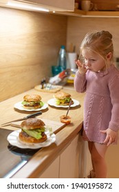 Little Blond Girl Is Cooking Home Made Burgers In Her Kitchen At Home