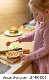 Little Blond Girl Is Cooking Home Made Burgers In Her Kitchen At Home