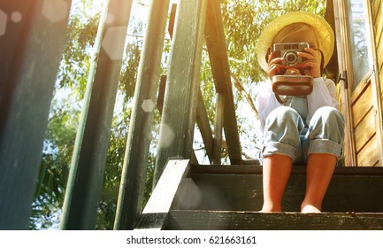 Little blond girl enjoying summer vacation time at the tree house. Gardening