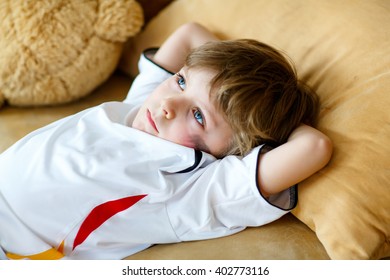 Little Blond Preschool Kid Boy After Watching Soccer European Cup Game On Tv. Sad Child About Lost Game Of His Football Team. Champions League Concept.