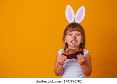 Little Blonde Girl With Dirty Chocolate Bunny Ears Eating Easter Cake