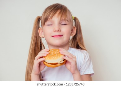 Little Blonde Girl Is Eating Baked Vegetarian Burger With Vegetables. Child Vegan Idea Healthy Eating Concept