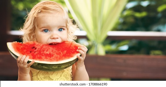 Little Blonde Girl Eating A Juicy Watermelon In The Garden. Children Eat Fruit On The Street. Healthy Food For Children. Toddler Gardening.Long Banner Format.