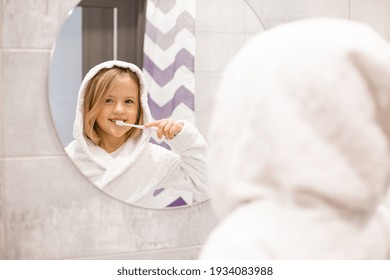 Little Blonde Girl Laughs Brushing Her Teeth At Home