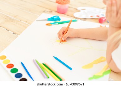 Little blonde girl painting on big white paper while laying on the floor indoors. - Shutterstock ID 1070899691
