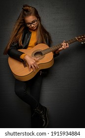 Little Blonde Girl Playing Guitar On Black Background