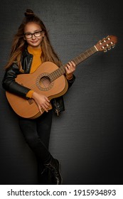 Little Blonde Girl Playing Guitar On Black Background