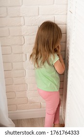 Little Blonde Girl Is Punished And Stands Alone In A Corner And Cries. The Child Misbehaved And Was Put In A Corner To Calm Her Down. Education And Punishment Of Children By Parents.