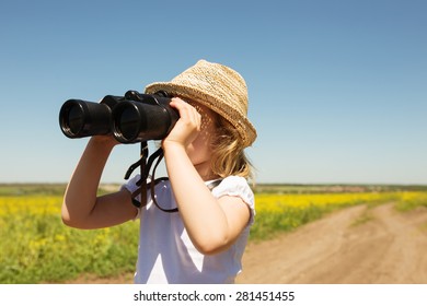 Little blonde girl in straw hat looking through binoculars outdoor - Shutterstock ID 281451455