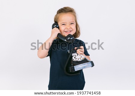 Little blonde girl talking on her retro phone