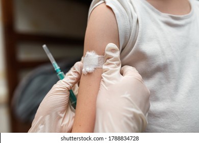 Little boy with a adhesive bandage on his shoulder after a vaccination injection. Prevention of children diseases through vaccination. Health care and medicine concept. Focus on shoulder. - Powered by Shutterstock