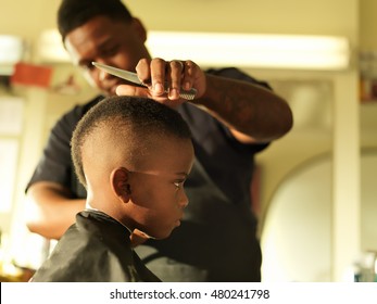 little boy in barbershop getting head shaved