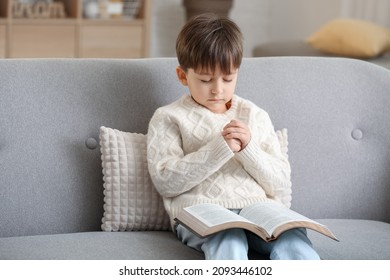 Little boy with Bible praying at home - Powered by Shutterstock