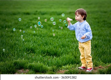 Little boy blowing soap bubbles, closeup portrait