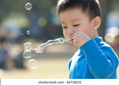 Little boy blowing soap bubbles