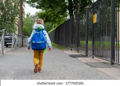 A Little Boy With Blue Bag Is Going To School. A Child Goes To Primary School At First Time. Back To School.