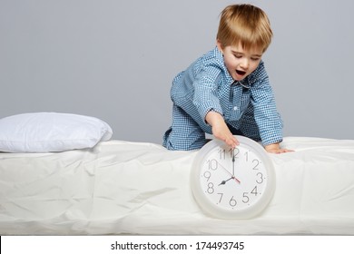 Little Boy In Blue Pyjamas With Clock 