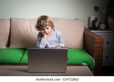 Little Boy Bored Watching Cartoons On Computer.