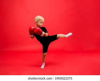 A Little Boy Boxer Stands Sideways In Red Boxing Gloves And Makes A Kick On A Red Background With Space For Text