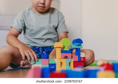 Little boy building tower of block toys sitting on floor at home. Developing skills. Baby development. Small house. - Shutterstock ID 2198703767