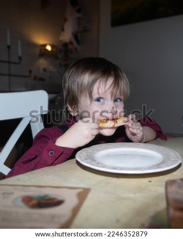 A little boy in a cafe eats pizza, a blue-eyed child eats in an Italian cafe