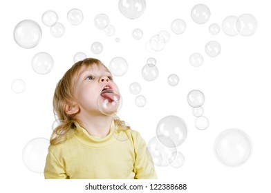 little boy catches soap bubbles on tongue