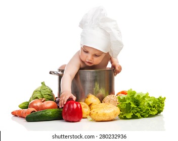 Little Boy In Chef's Hat Reaching For Bell Pepper While Sitting In Large Casserole Over White